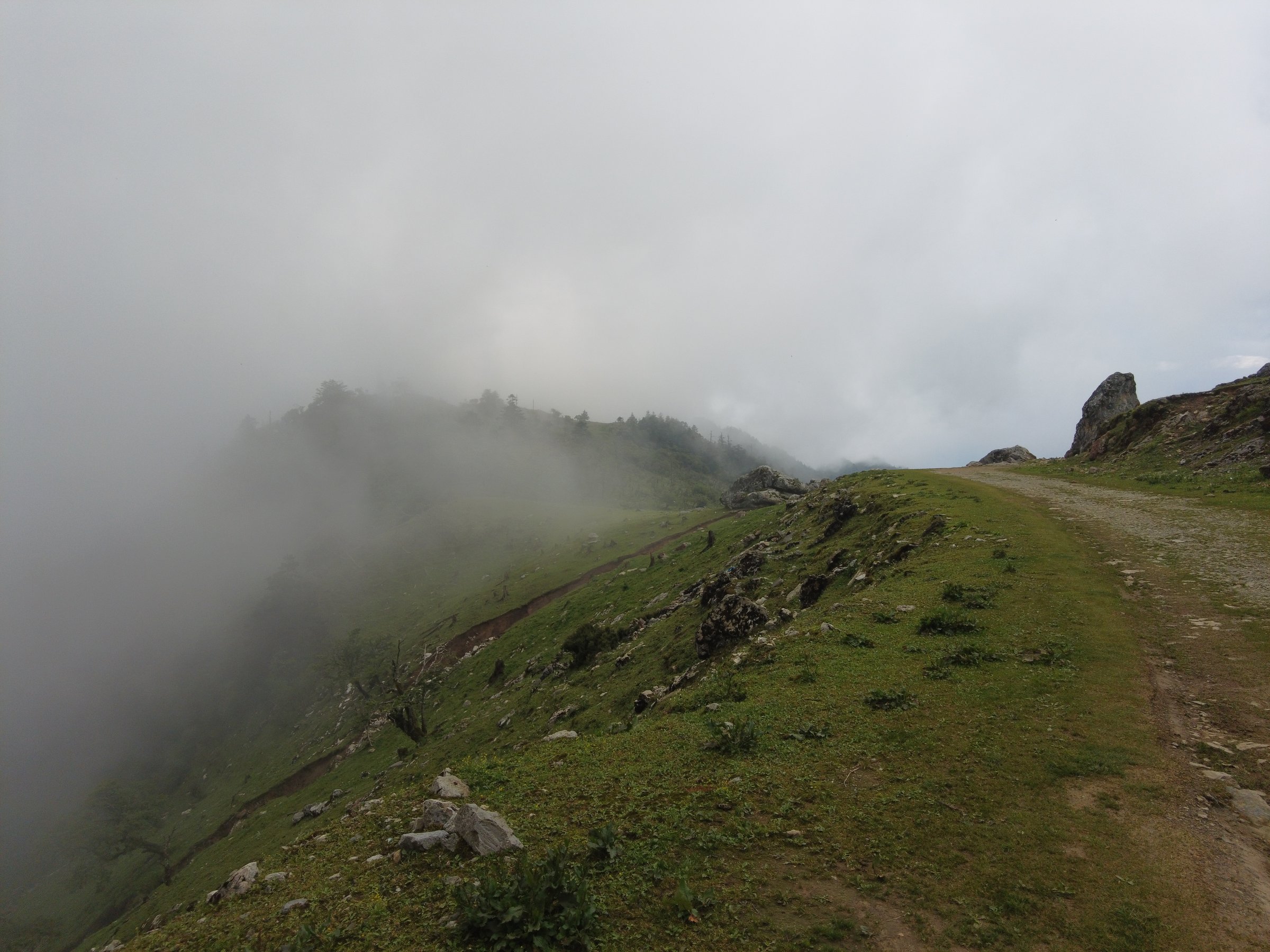 Cloud spilling over a ridge, a gravel track leading into the fog